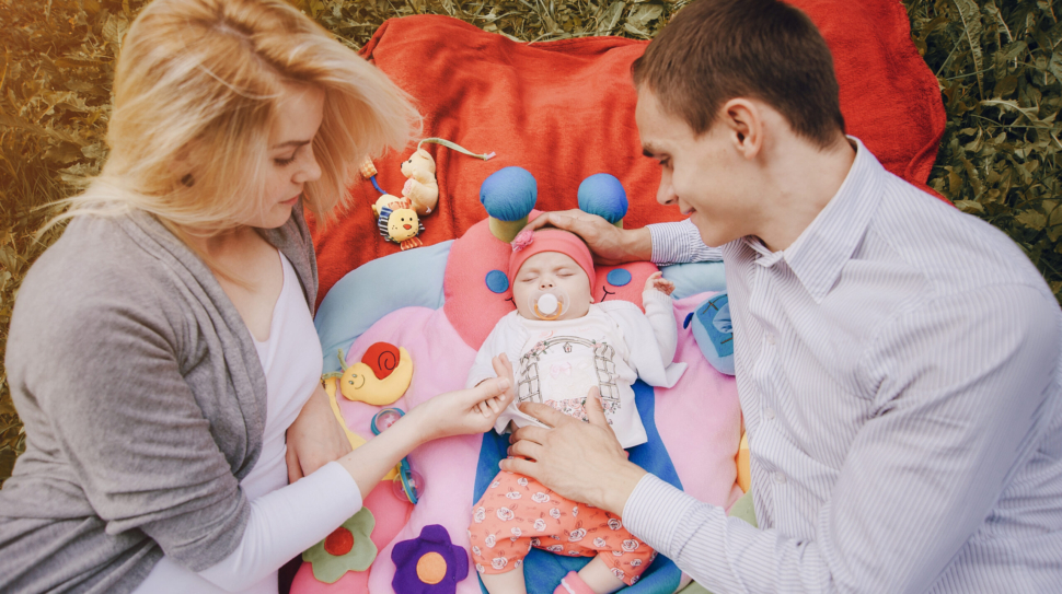 young-parents-looking-their-sleeping-baby